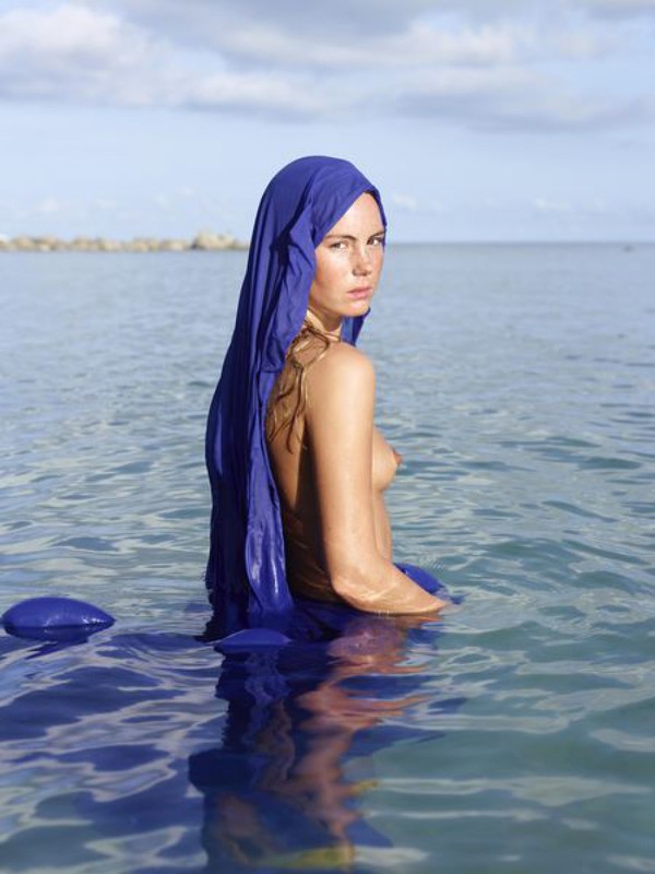 Обнаженная девушка с синей тряпкой на море 7 фото