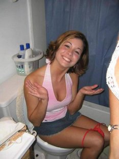 Веселые девушки сидят на унитазе в туалете
