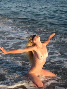 Голая девушка купается в море в жару